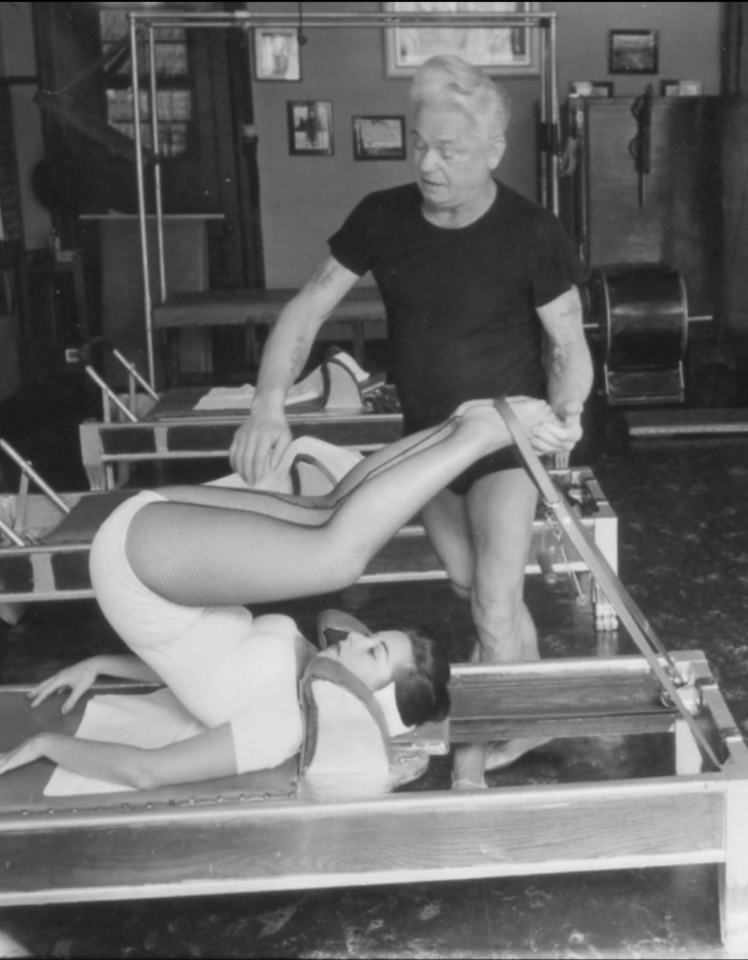 Archival photograph of Joseph Pilates teaching on the Reformer